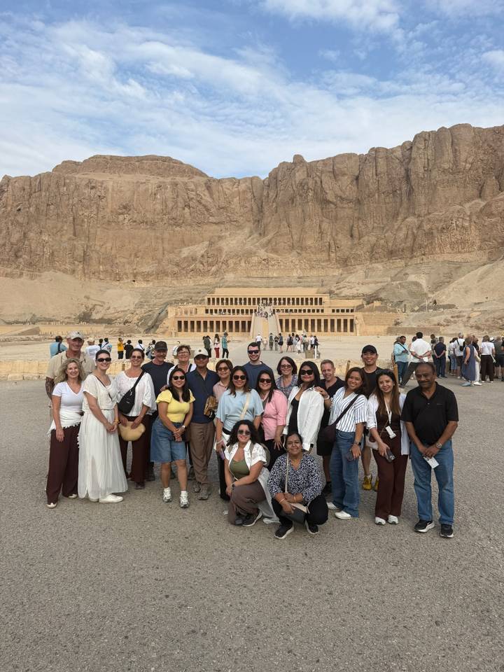 Group photo in front of the monumental Temple of Hatshepsut carved into desert cliffs.