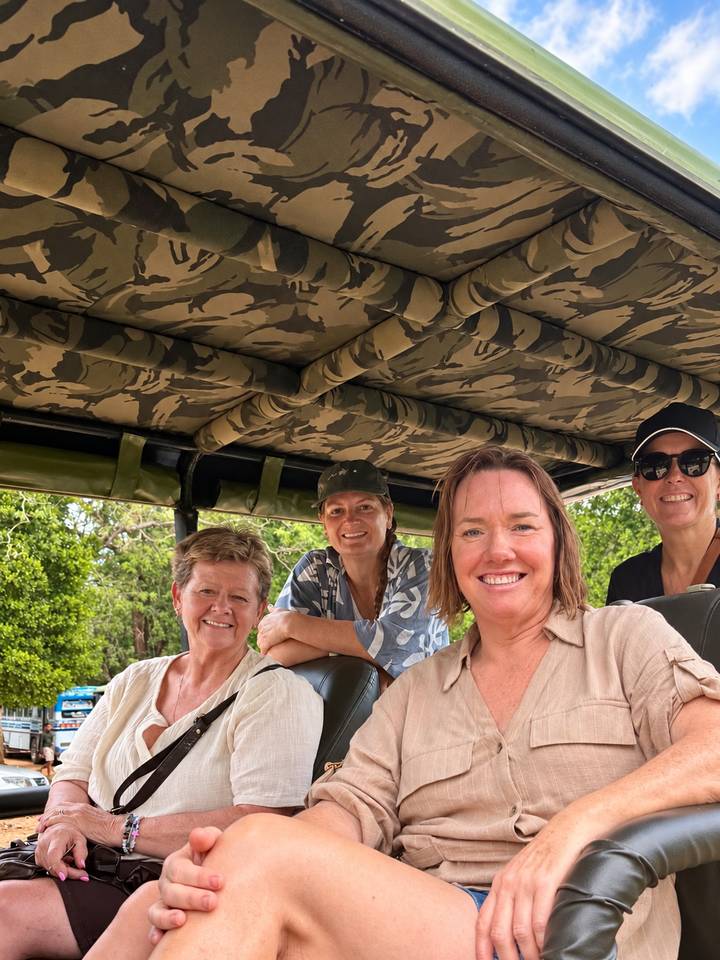 Group inside an open-air camouflage safari jeep ready for wildlife drive.
