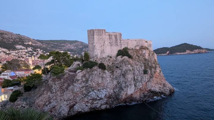 Fort Lovrijenac perched on a rocky cliff above the blue Adriatic with Dubrovnik rooftops nearby.