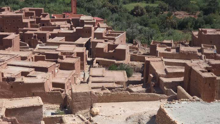A maze of flat-roofed adobe homes and alleys seen from above in an oasis village near Ait Benhaddou.