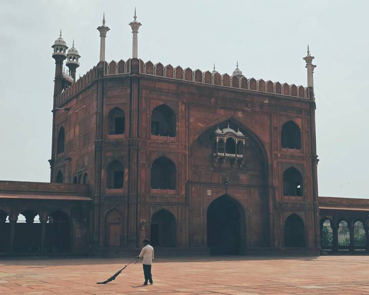 Historic red-sandstone gate of Jama Masjid featuring arched windows and slender minarets