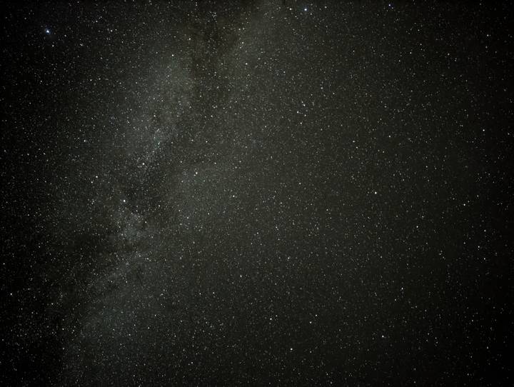 Clear night sky filled with thousands of stars and the Milky Way band stretching across.