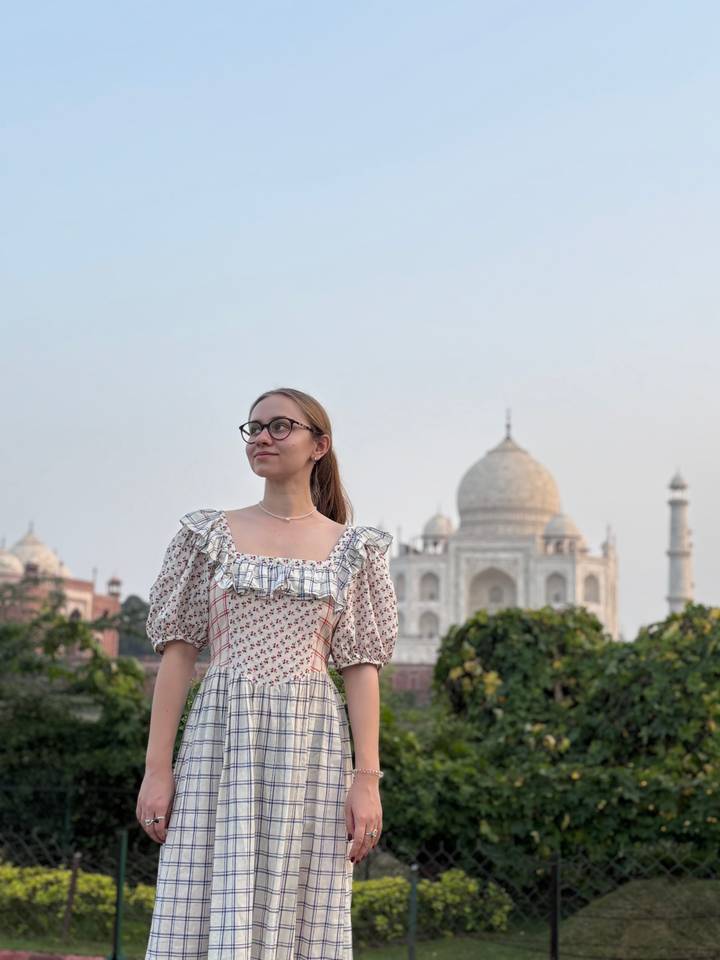 Young woman posing in front of the Taj Mahal on a clear day