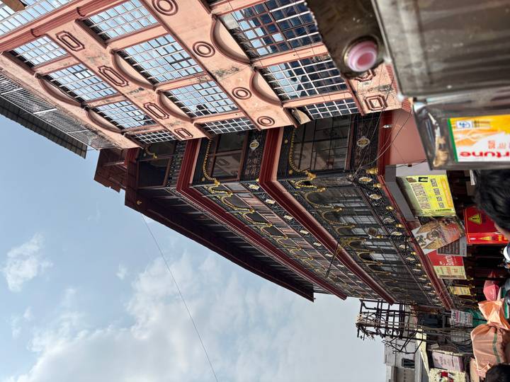 Colorful multi-storey commercial building and street signs in a busy Indian market