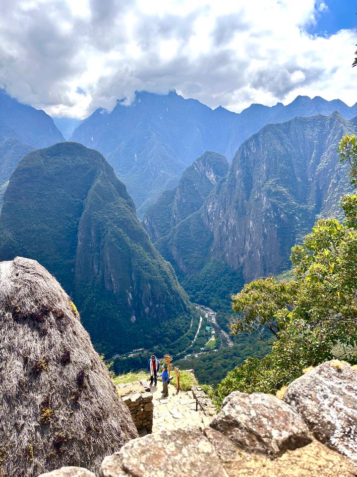 Dramatic green peaks of the Andes rise above a winding river far below.