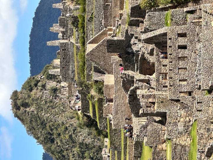 Stone structures and terraces of Machu Picchu framed by a mountain backdrop.