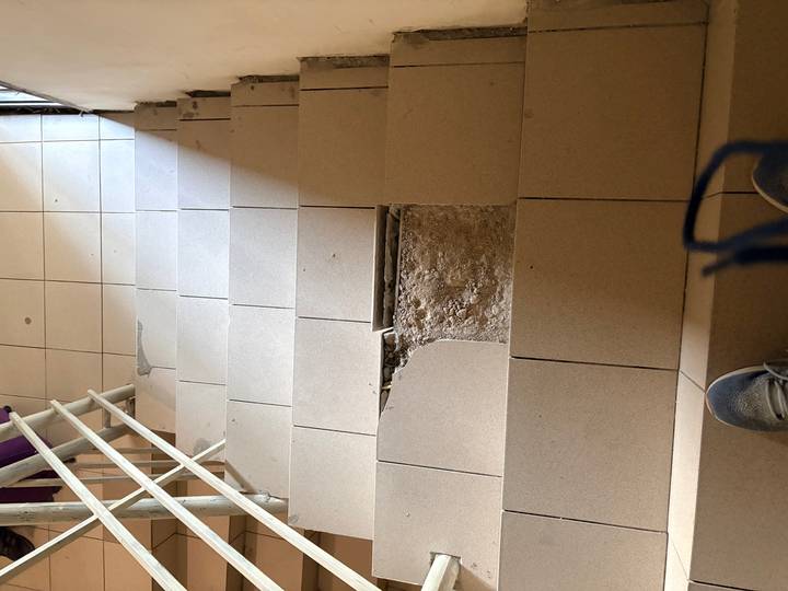 Damaged staircase with missing tile exposing concrete underneath