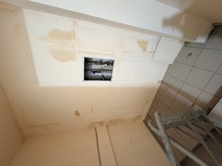 Interior wall with stains and an open service panel in a stairwell