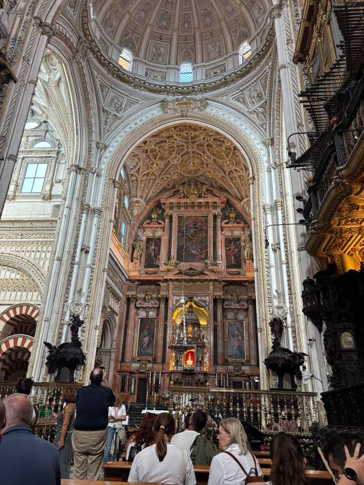 Lavish interior nave of the Mezquita-Catedral de Córdoba with intricate arches and altar.