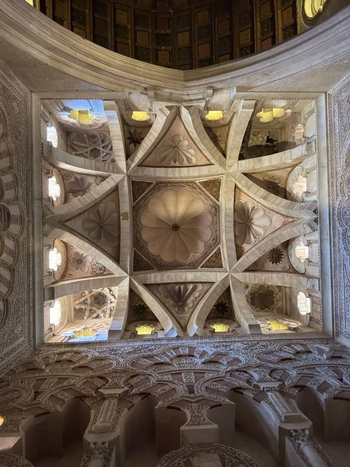 Stone ceiling with ornate geometric and floral patterns inside a historic cathedral.