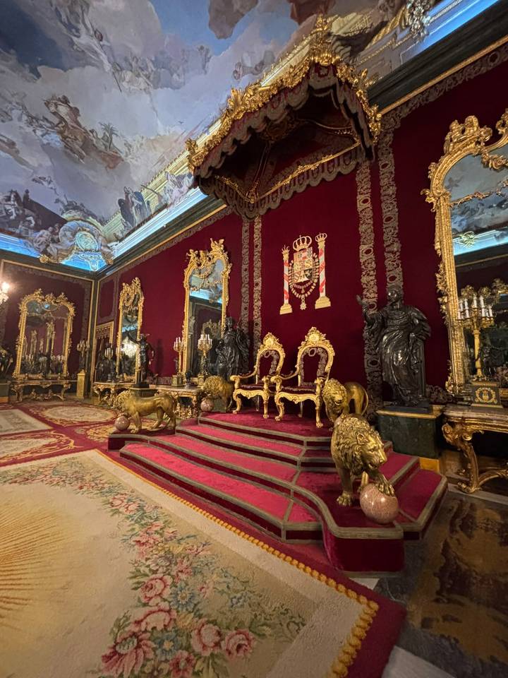 Rich red throne room with gilded lions and mirrors in the Royal Palace of Madrid.