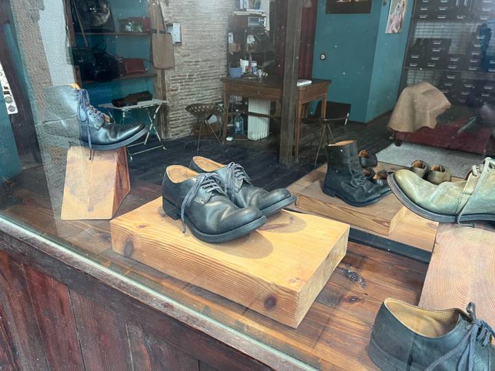 Display of handcrafted leather shoes in a boutique shop window.