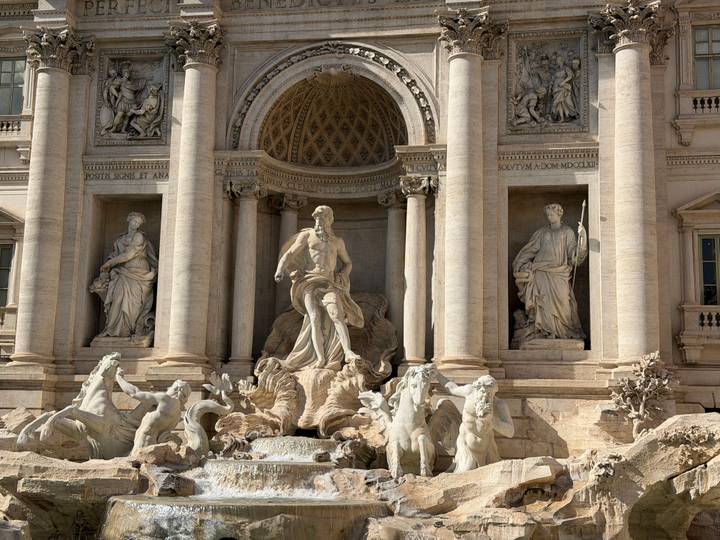 Baroque marble sculptures and cascading water of Rome's Trevi Fountain.