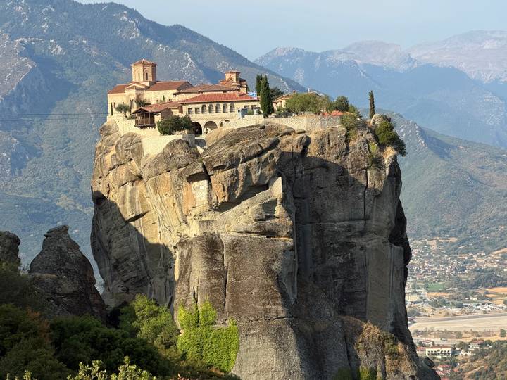 Monastery perched dramatically atop a towering Meteora sandstone pinnacle.