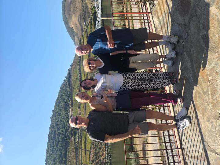 Travel companions enjoying wine with terraced Douro Valley vineyards in the background.