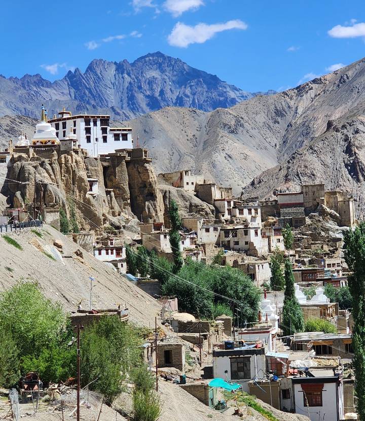 The cliff-side Lamayuru Monastery complex clings to rugged rock formations amid arid mountains.