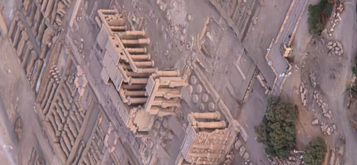 Slightly soft aerial view of a large temple complex and surrounding excavations in the desert taken from a hot-air balloon.