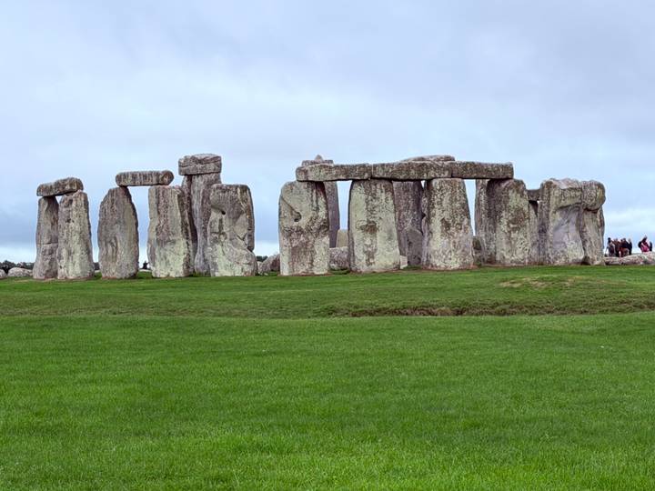 The prehistoric stone circles of Stonehenge stand stark against an overcast sky.