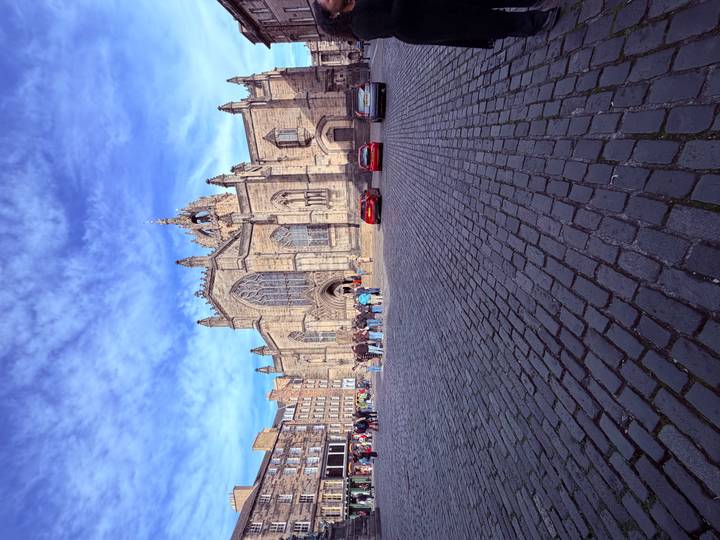 Crowds gather on a cobbled square in front of the ornate façade of St Giles' Cathedral in Edinburgh.