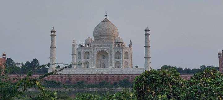 Classic frontal view of the white marble Taj Mahal framed by greenery.