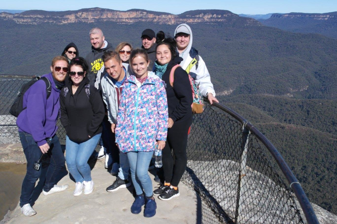 A group of people posing at a mountainous viewpoint.