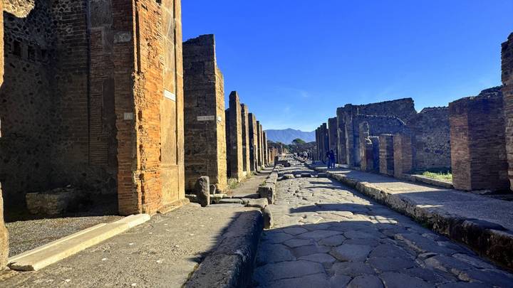 Stone roadway flanked by brick columns in the ancient ruins of Pompeii.