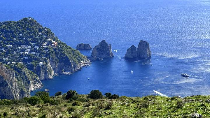 Faraglioni sea stacks rise from turquoise waters off Capri’s rugged coast.