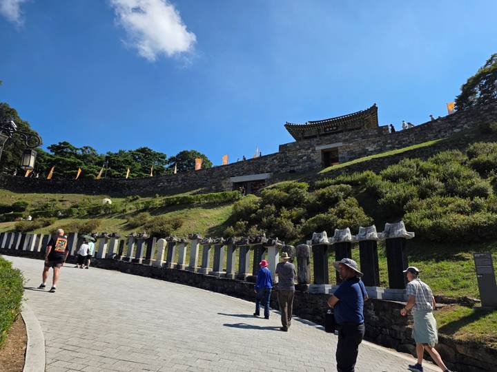 Citadel walls and visitors walking below a historic fortress on a sunny day