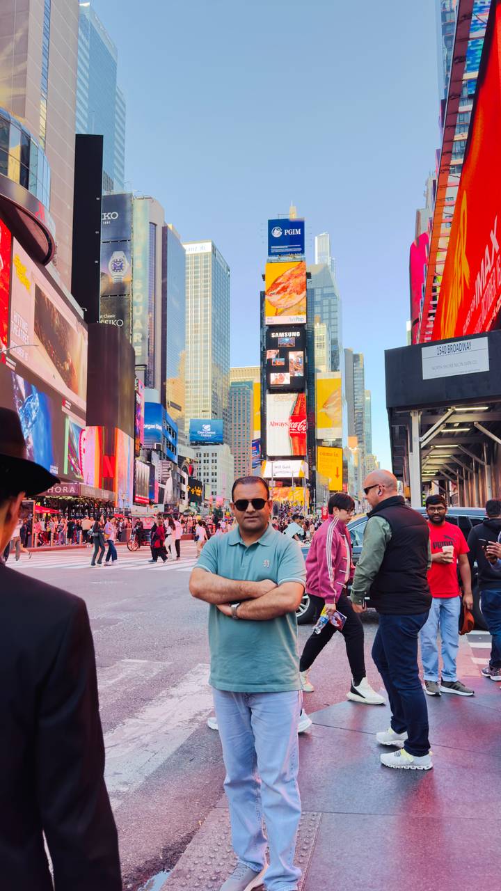 Crowds bustle through Times Square filled with bright billboards and towering buildings