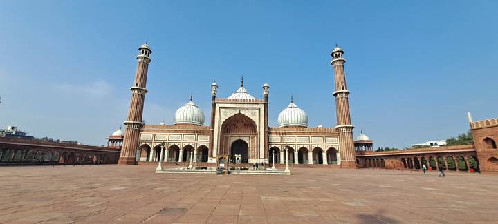 Expansive courtyard facing the grand Jama Masjid mosque under a clear sky