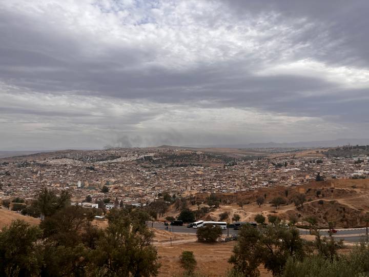 Wide panorama of Fes city sprawled beneath a dramatic overcast sky
