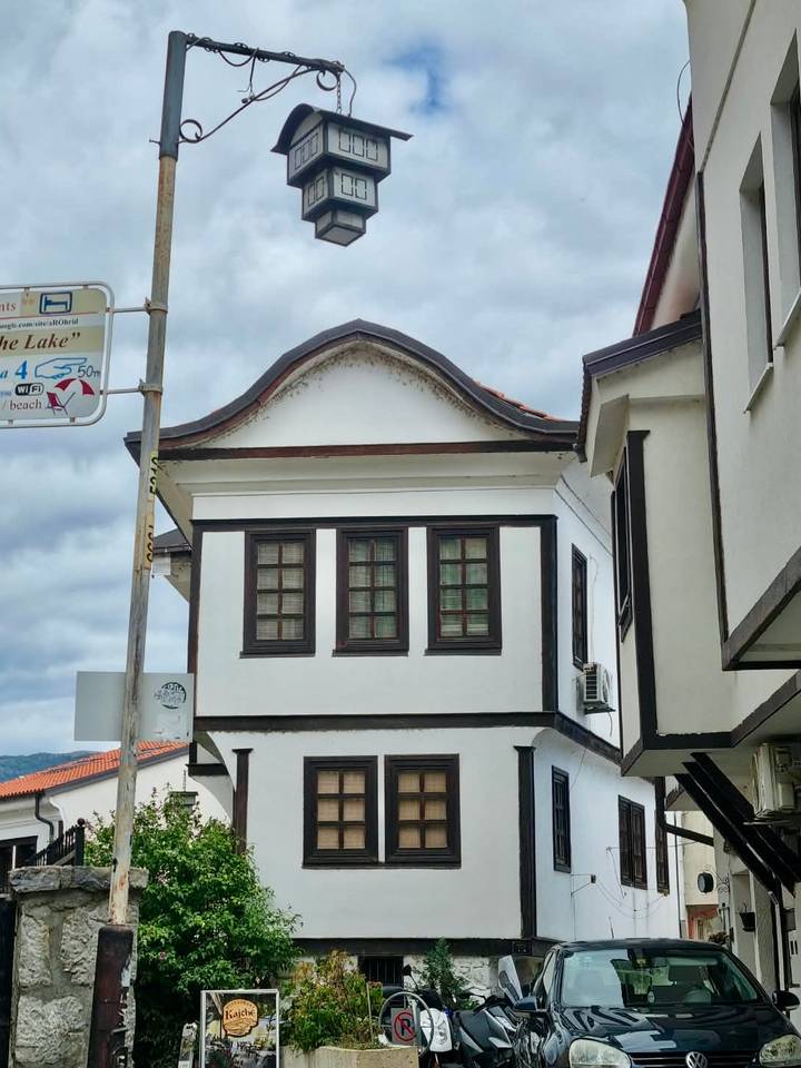 Traditional white-walled Ottoman-style house with dark wood trim under a cloudy sky in Ohrid.