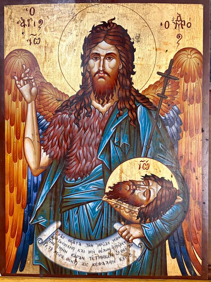 Vibrant Orthodox icon painting of St. John the Baptist holding a medallion with his own head.