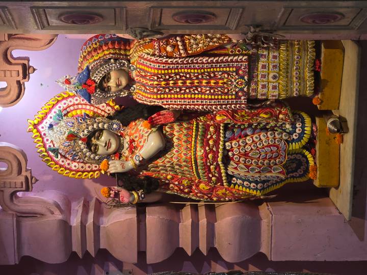 Colorful decorated Hindu deity statues displayed inside a shrine.