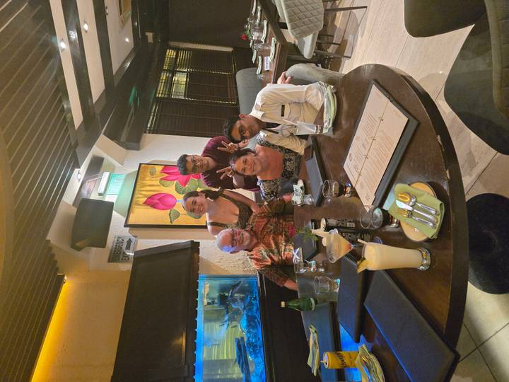 Friends gathered around a dinner table in a modern restaurant.
