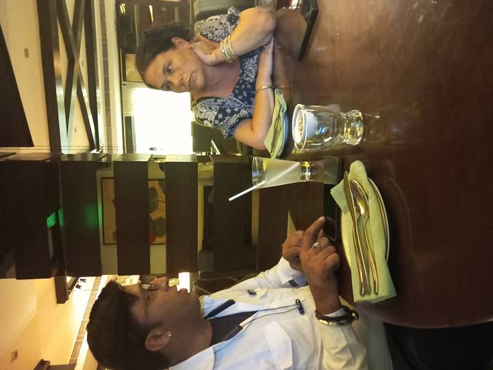 Two people chatting across a restaurant table with drinks.
