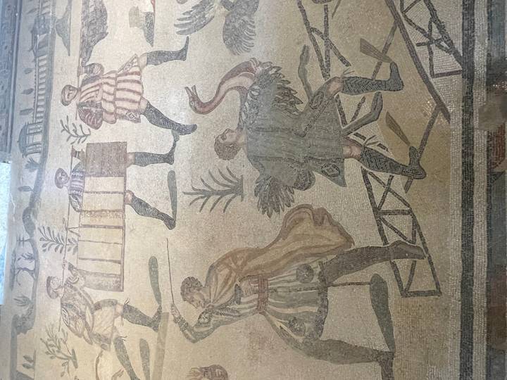 Detailed floor mosaic depicting ancient figures and animals in muted colors.