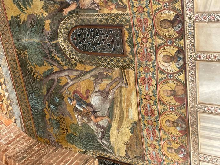 Colorful Byzantine mosaic artwork and portraits inside a historic church interior.