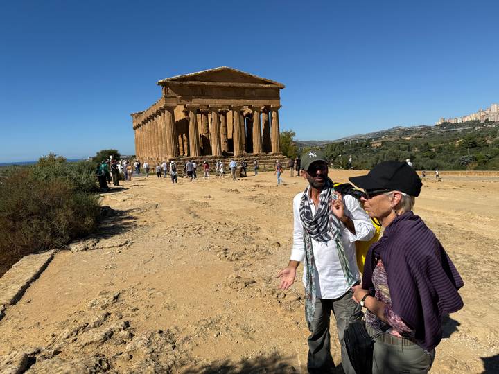 Tour participants and guide discussing the well-preserved Temple of Concordia in Agrigento’s Valley of the Temples