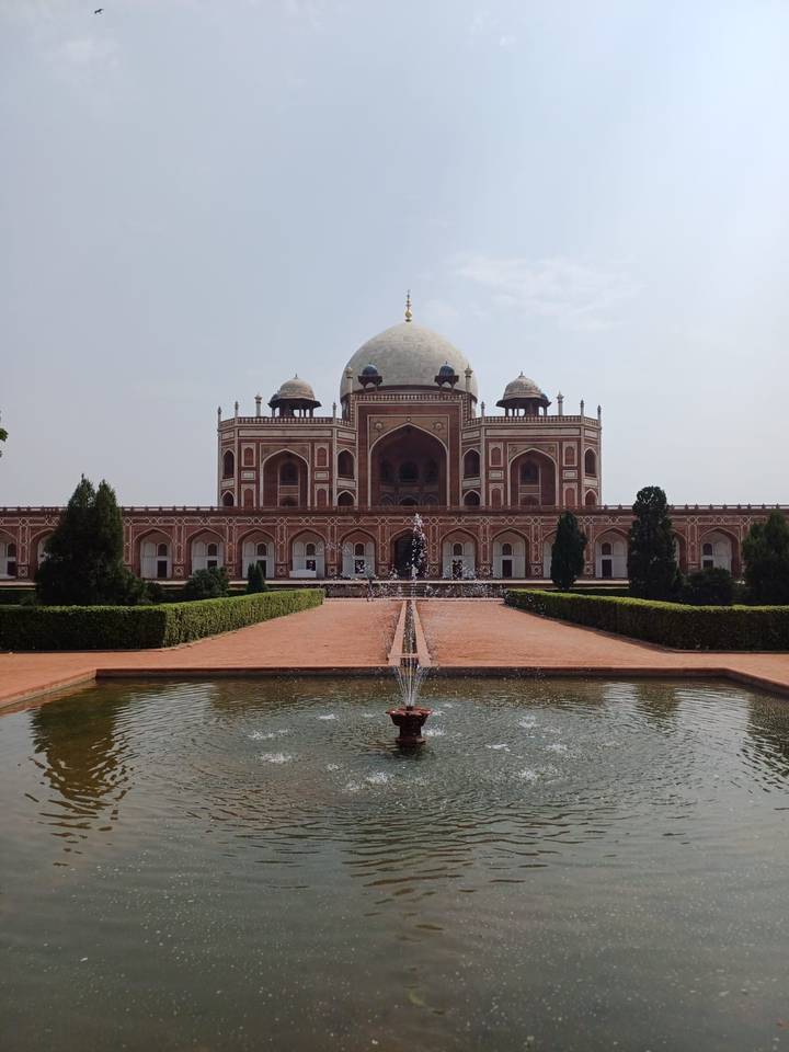 Symmetrical view of Humayun’s Tomb with fountain jets in the foreground.