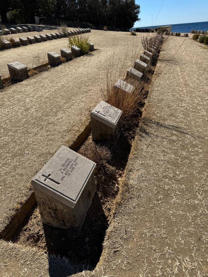 Simple stone grave markers in a dry, windswept WWI cemetery at Gallipoli.