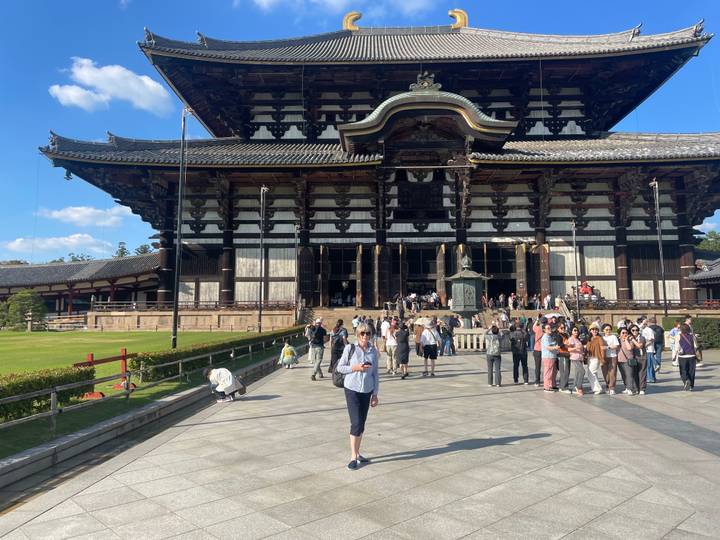 Front of Tōdai-ji temple with visitors gathered on the stone courtyard.