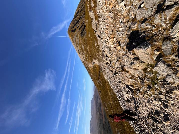 Rocky mountain trail leading up Croagh Patrick under deep blue sky with thin cloud streaks.