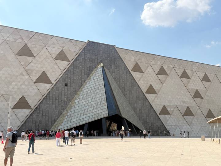 Visitors enter the pyramid-shaped glass main gate of Egypt’s new museum complex.