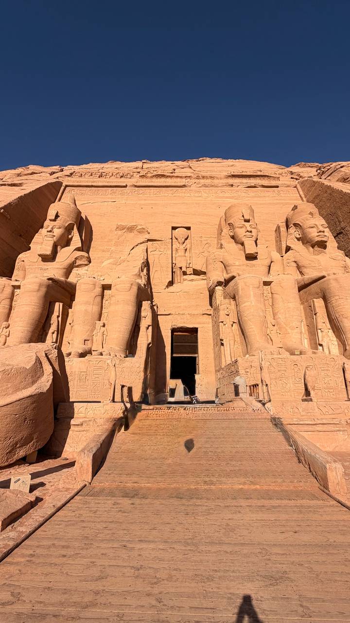 Closer view of Abu Simbel entrance reveals hieroglyphs and towering pharaoh statues.