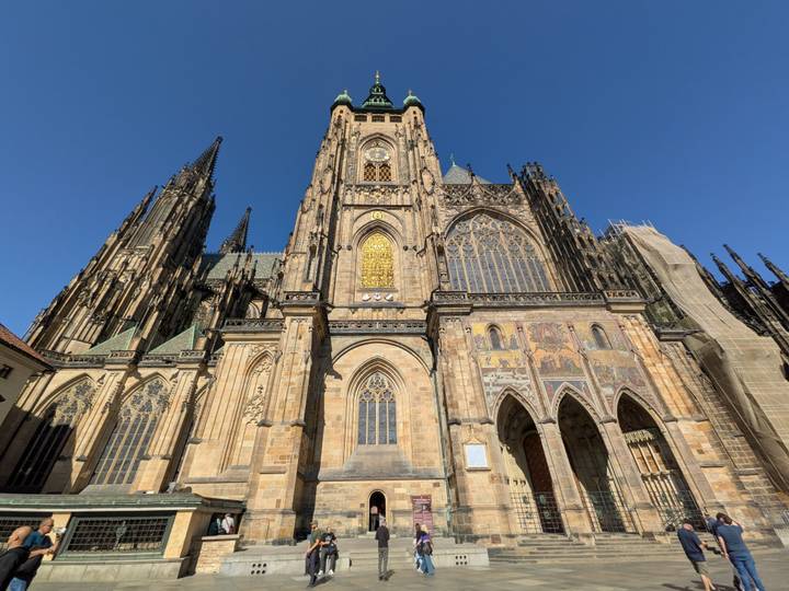 Grand gothic façade of St. Vitus Cathedral against a clear blue sky.