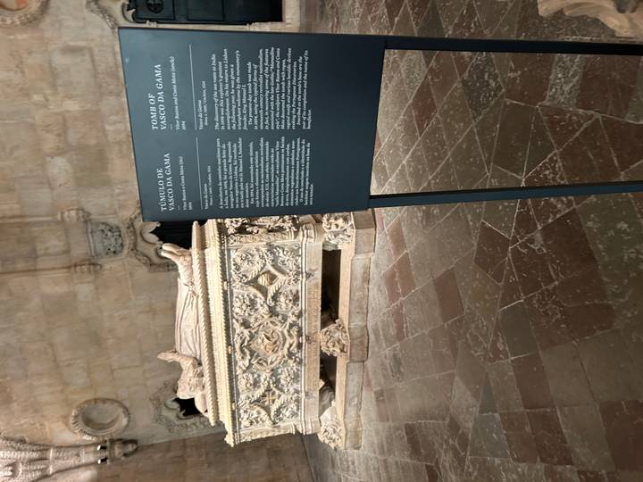 Interior shot of Vasco da Gama’s ornate stone tomb with an information panel inside a monastery