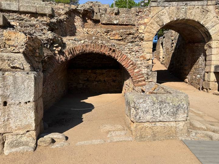Stone arches and ancient masonry remnants of a Roman ruin in bright sunlight