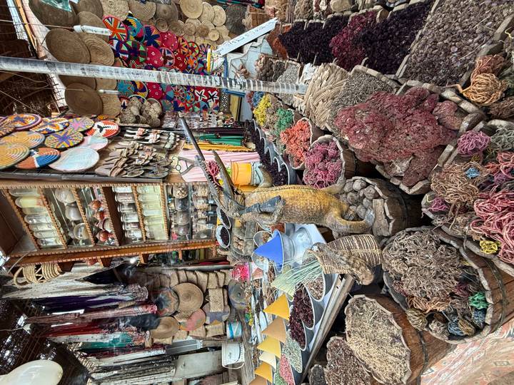 Colorful spice and herb market stall overflowing with baskets of goods in Aswan souk