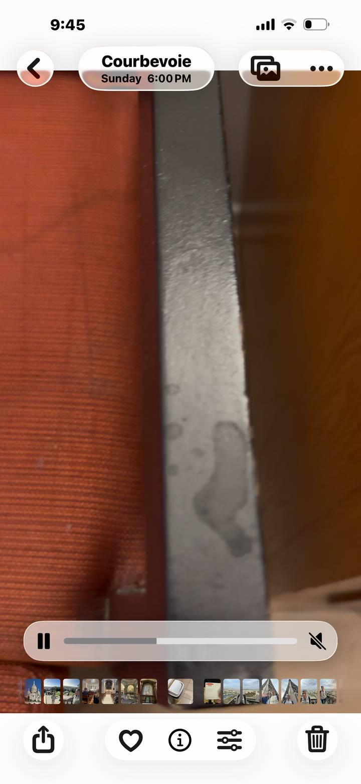 Blurry image of the edge of a seat and a wooden surface.